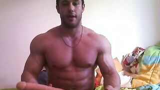 Hot bodybuilder playing with toy