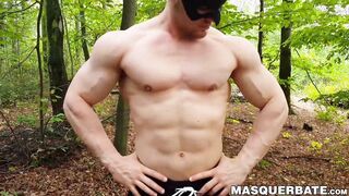 Muscular dude strokes his cock outdoors while wearing a mask